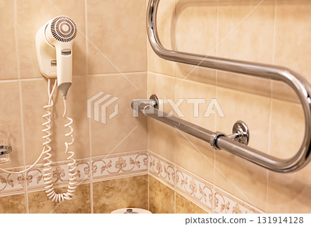 Bathroom with hairdryer, grab bars, glass holders, and toilet paper roll. Bathroom with hairdryer, grab bars, glass holders, and toilet paper roll. 131914128
