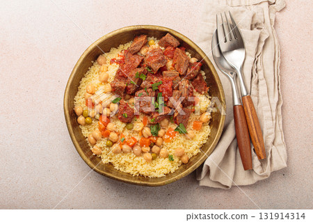 Moroccan couscous with tender meat and chickpea stew in rustic bow top view, Maghreb cuisine Moroccan couscous with tender meat and chickpea stew in rustic bow top view, Maghreb cuisine 131914314