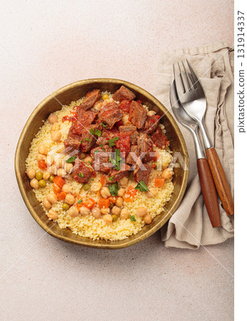 Moroccan couscous with tender meat and chickpea stew in rustic bow top view, Maghreb cuisine 131914337