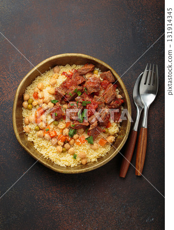 Moroccan couscous with tender meat and chickpea stew in rustic bow top view, Maghreb cuisine 131914345