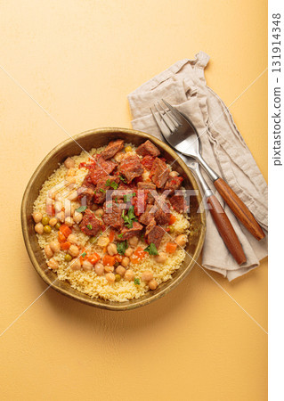 Moroccan couscous with tender meat and chickpea stew in rustic bow top view, Maghreb cuisine Moroccan couscous with tender meat and chickpea stew in rustic bow top view, Maghreb cuisine 131914348