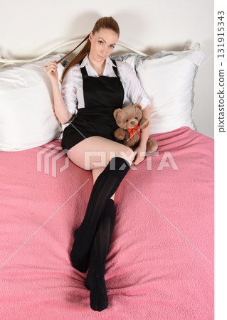 Attractive redhead model dressed as a fantasy StTrinians schoolgirl, on her bed Attractive redhead model dressed as a fantasy StTrinians schoolgirl, on her bed 131915343