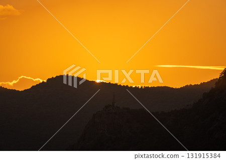 Sunset mountains horizon silhouette landscape. Golden orange sky above dark peaks, majestic view from nature. Sunset mountains horizon silhouette landscape. Golden orange sky above dark peaks, majestic view from nature. 131915384