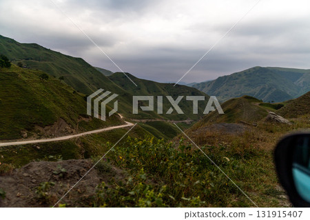 A mountain range with a road that winds through it 131915407