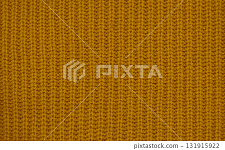 Close-up of warm mustard yellow knitted wool texture, cozy autumn winter fabric background 131915922