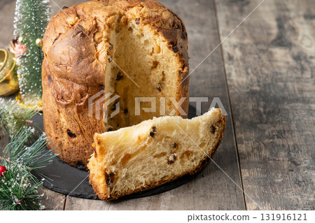 Traditional Italian Panettone on wooden table and christmas tree Traditional Italian Panettone on wooden table and christmas tree 131916121