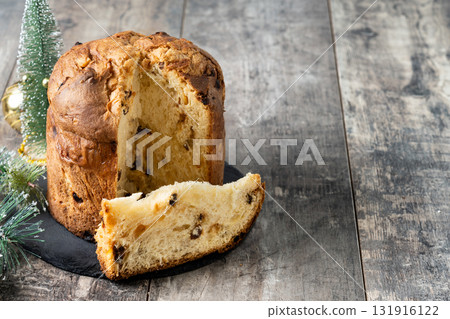 Traditional Italian Panettone on wooden table and christmas tree 131916122