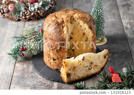 Traditional Italian Panettone on wooden table and christmas tree 131916123