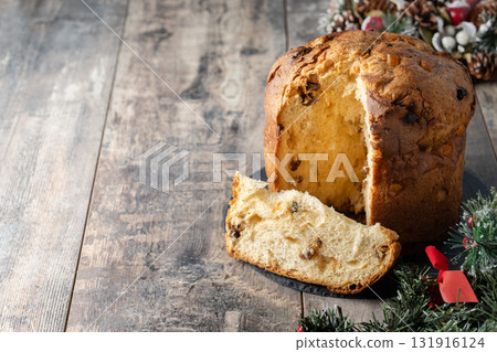Traditional Italian Panettone on wooden table and christmas tree 131916124