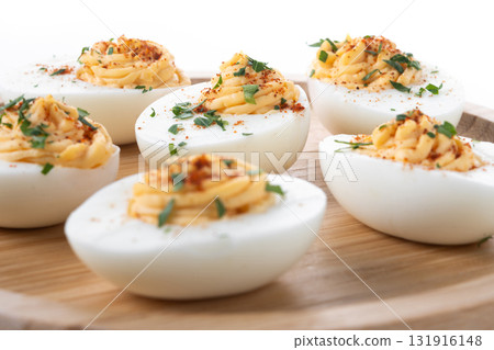 Homemade hard Boiled Deviled Eggs garnished with herbs 131916148