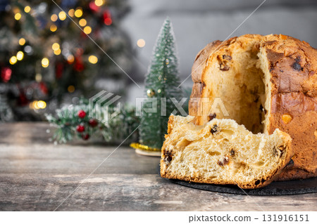 Traditional Italian Panettone on wooden table and christmas tree Traditional Italian Panettone on wooden table and christmas tree 131916151