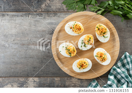 Homemade hard Boiled Deviled Eggs garnished with herbs 131916155