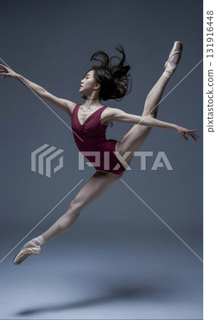 Woman in a red dress is doing a pirouette 131916448