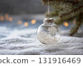 Glass ornament with snowflakes on it is hanging from a tree 131916469