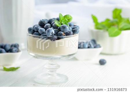 Panna cotta with fresh blueberries in a clear bowl. Panna cotta with fresh blueberries in a clear bowl. 131916873