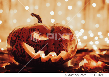 Creepy smiling pumpkin with candle lights inside, close up. Halloween, autumn holiday, religion, homemade decoration concept 131916912