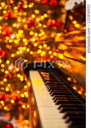 Piano keyboard and bright lights of electric garland on the background. Celebration of Christmas, festive atmosphere at home Piano keyboard and bright lights of electric garland on the background. Celebration of Christmas, festive atmosphere at home 131916952