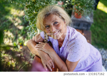 Selfacare moment for elderly woman, quiet time in garden. Selfacare moment for elderly woman, quiet time in garden. 131917162