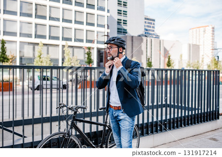 Urban commuter putting helmet on head before ride. 131917214