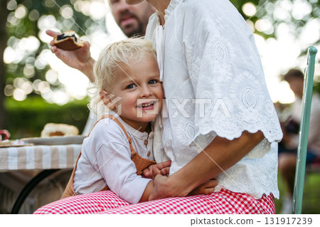 Toddler hugging his mom during family garden party. Toddler hugging his mom during family garden party. 131917239