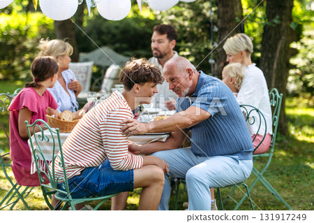Grandson talking and laughing with grandfather. 131917249