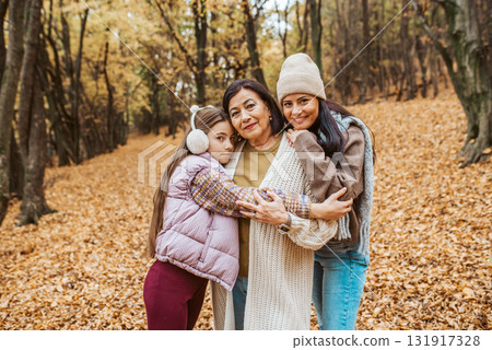 Mature daughter, grandmother and granddaugter on walk in autumn forest. Mature daughter, grandmother and granddaugter on walk in autumn forest. 131917328