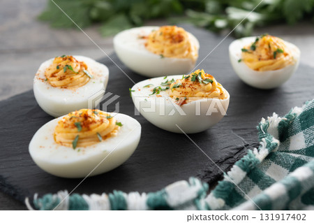 Homemade hard Boiled Deviled Eggs garnished with herbs 131917402
