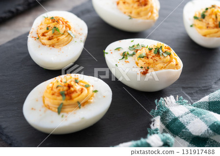 Homemade hard Boiled Deviled Eggs garnished with herbs 131917488