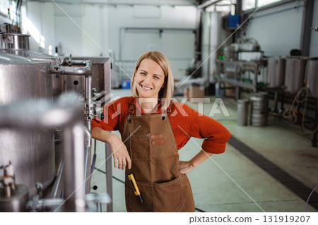 Woman brewer smiling in craft beer brewery 131919207