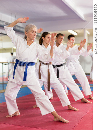 Karate or taekwondo training - athletes in kimono stand in fighting stance Karate or taekwondo training - athletes in kimono stand in fighting stance 131919430