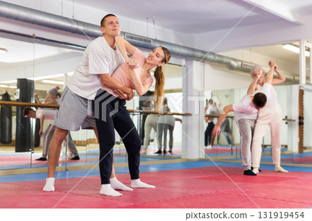 Self-defense course - a woman trains to do painful grip and painful blows to man Self-defense course - a woman trains to do painful grip and painful blows to man 131919454