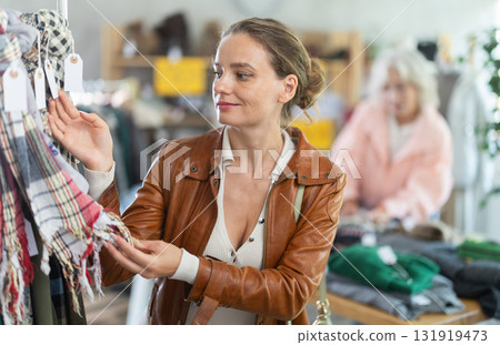 European woman customer examine and choose scarf in store European woman customer examine and choose scarf in store 131919473