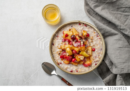 Overnight oatmeal with apples, cranberries, and cinnamon in a bowl on a light background 131919513