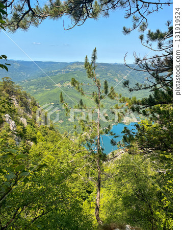 Canyon river meandering among green forested mountains; nature landscape photography under blue sky 131919524