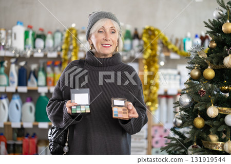 Elderly woman chooses cosmetics in decorated household chemicals store Elderly woman chooses cosmetics in decorated household chemicals store 131919544
