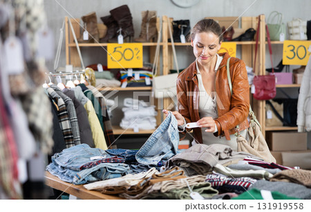Woman choosing jeans in a store Woman choosing jeans in a store 131919558