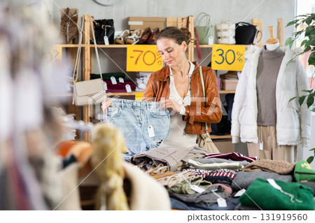 Woman choosing jeans in a store Woman choosing jeans in a store 131919560
