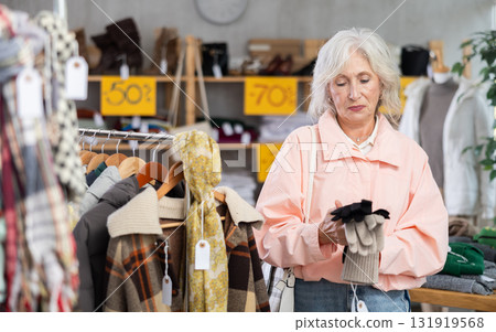 Elderly woman choosing gloves in the store Elderly woman choosing gloves in the store 131919568