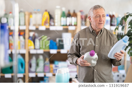 Senior man select and studies label liquid detergent Senior man select and studies label liquid detergent 131919687
