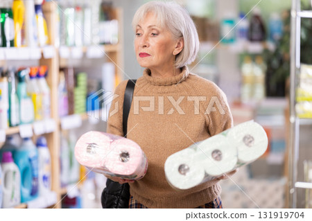Woman choosing a set of toilet paper 131919704