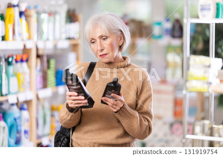 Mature woman chooses products for glass-ceramics 131919754