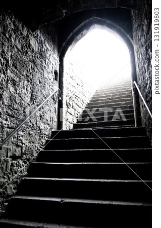 Steep Stone Stairs In Ancient Building With Massive Walls Towards An Exit With Bright Light Steep Stone Stairs In Ancient Building With Massive Walls Towards An Exit With Bright Light 131919803