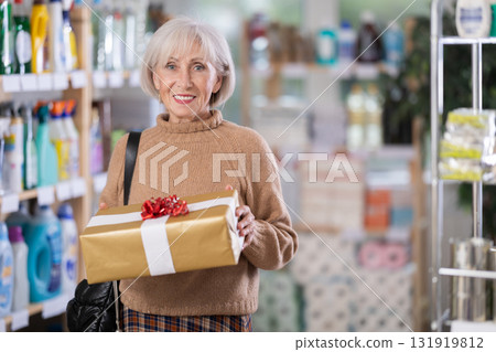 Mature woman holding present in department store 131919812