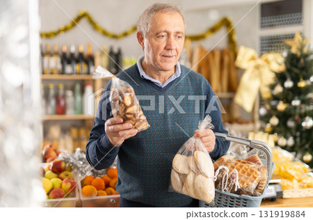 Retired man chooses cookies for a holiday table in supermarket 131919884