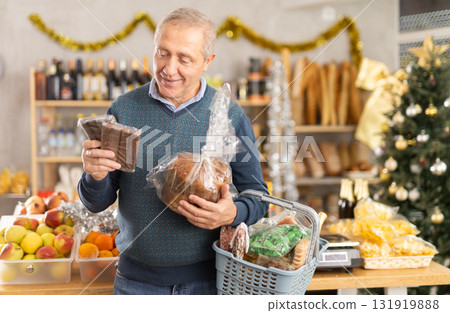 Portrait of mature man buying chocolate and chocolate candies for gift and celebrating Christmas Portrait of mature man buying chocolate and chocolate candies for gift and celebrating Christmas 131919888