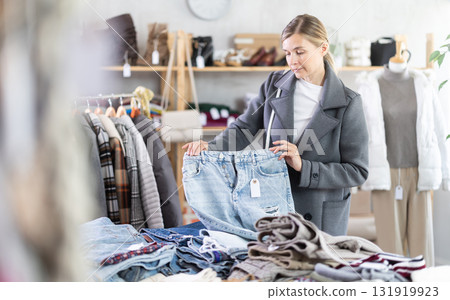 Woman browsing goods items and choose elect jeans trousers 131919923
