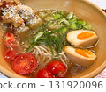 Close-up a bowl of ramen with egg, tomatoes and sesame chicken on skewers. Warm broth, Japanese dining culture and culinary harmony through texture, color and taste balance. 131920096