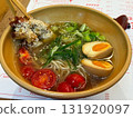 A bowl of ramen with egg, cherry tomatoes and sesame chicken. Asian cuisine, comfort food and dining experience representing balance, flavor and culinary aesthetics. 131920097