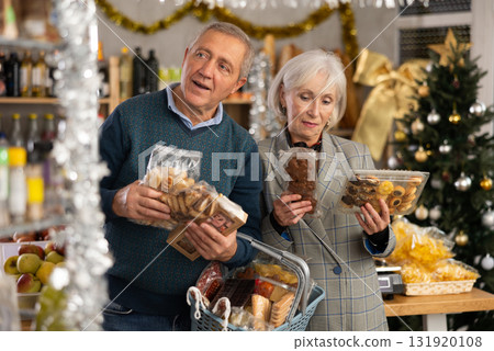 Elderly husband and wife choose delicious cookies for their festive Christmas table at supermarket Elderly husband and wife choose delicious cookies for their festive Christmas table at supermarket 131920108