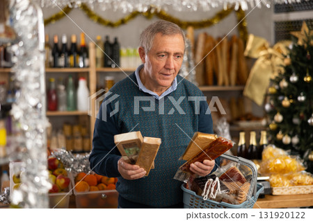 Male shopper selects nougat in grocery section of supermarket for gifting and celebrating Christmas 131920122